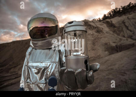 Spaceman esplorando il pianeta anonimi, analizzatore di contenimento Foto Stock