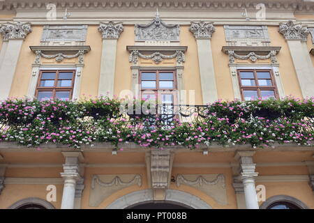 Dettaglio della facciata barocca di Casa di città di Kosice. Le finestre sono decorate con ornamenti e balcone con fiori. Foto Stock