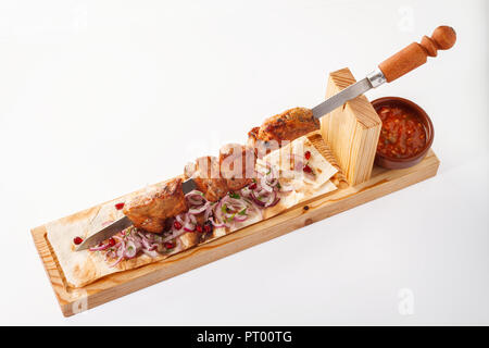 Khorovats- piatto tradizionale di agnello armeno Kebab/spiedini su tavola di legno. Servito su pane piatto su fondo bianco. Foto Stock