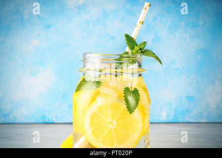 Coctail giara di limonata e foglie di menta sul tavolo di legno sfondo blu naturale di acqua di limone cibo fatto in casa è popolare detox vetro bevanda antiossidante di infusione. Foto Stock