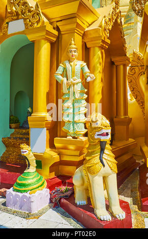 Il gruppo di statue religiose presso il piccolo stupa esterna di Shwedagon Zedi Daw: il serpente Naga-Raja, Chinthe leogryph e Nat spirito scultura su backg Foto Stock