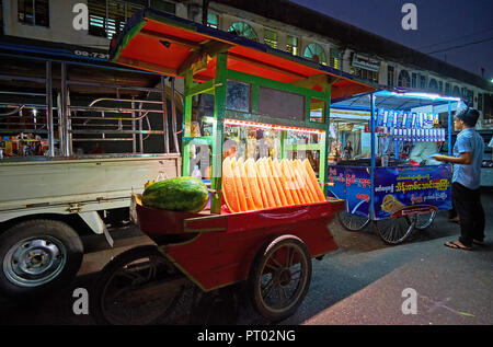 YANGON, MYANMAR - Febbraio 27, 2018: la street food cart in Tawya Gyar street market illuminato con fette di anguria rinfrescante, il 27 febbraio Foto Stock