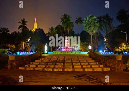 YANGON, MYANMAR - Febbraio 27, 2018: la fontana di illuminazione in sera Theingottara park, situato ai piedi della collina di Singuttara con una vista sulla luminosa Foto Stock