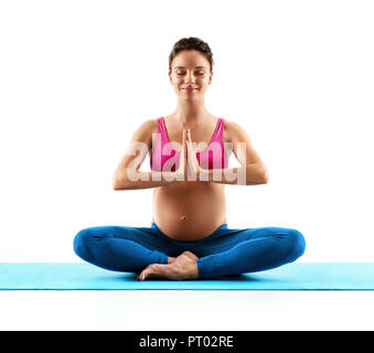 Gravidanza donna fare yoga pratica isolata su sfondo bianco. Concetto di vita sana Foto Stock