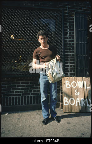 Stati Uniti : New York. Agosto 1981. In strada, in corrispondenza del fondo di un edificio di mattoni, Lou Reed guardando i tre 10x15 immagini di John Lennon a Foto Stock