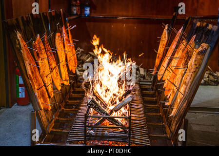 Fiammata delizioso salmone affumicato su un fuoco aperto al mercato di Natale . Foto Stock