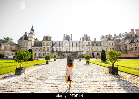 FONTAINBLEAU, Francia - 28 agosto 2017: Vista sul palazzo con donna tornando a piedi a Fontainebleau, Francia Foto Stock