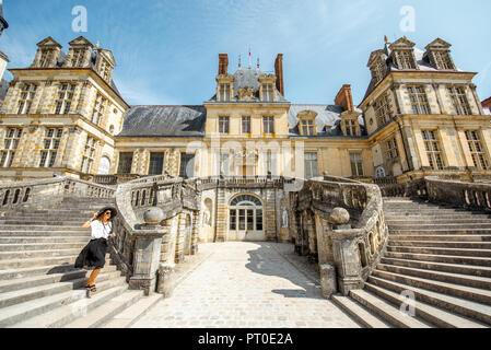 FONTAINBLEAU, Francia - 28 agosto 2017: Donna in esecuzione sulla bella scalinata di visitare la famosa Palazzo Fontainebleau in Francia Foto Stock