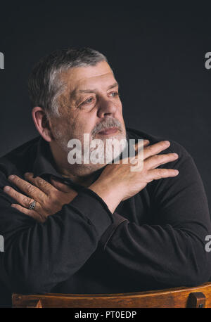 Nizza chiave di basso ritratto del barbuto uomo caucasico meditando nel buio Foto Stock