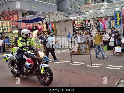 Polizia Stradale rider di pattuglie a fianco il Ladies Market in Mong Kok, Kowloon, Hong Kong Foto Stock