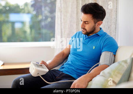 L'uomo controllare la sua pressione del sangue Foto Stock