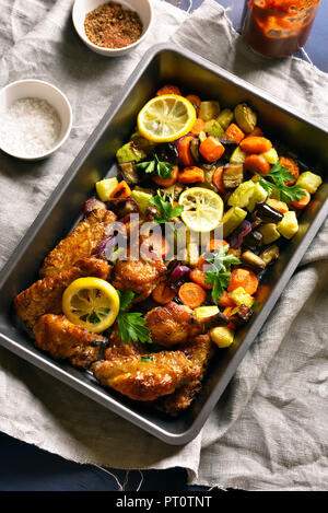 Grigliata di ali di pollo con verdure nel vassoio da forno. Vista superiore Foto Stock