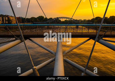 Cracovia, la Piccola Polonia / Polonia - 2018/09/08: Cracow Old Town, vista serale del moderno ponte pedonale Kladka Ojca Bernatka sulla Vistola rive Foto Stock