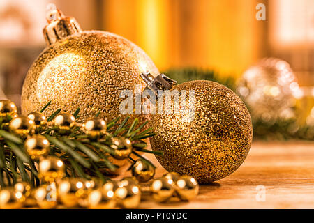 Goldene christbaumkugel mit Tannenzweig, Kerze, Lichter und Deko Foto Stock