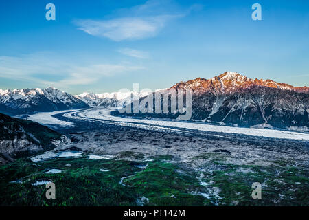 Alle quattro del mattino il giugno sole illumina il picco di Mt. Wickersham sopra il ghiacciaio Matanuska. Nuvole di luce dot il cielo e le cime del Foto Stock