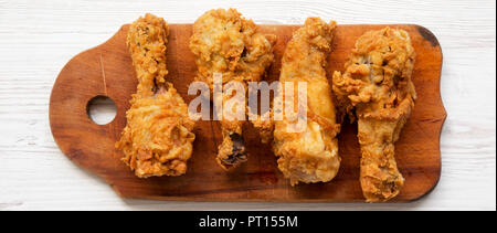 Fritto di pollo Cosce di pollo disossate sulla tavola di legno bianco su una superficie di legno, vista dall'alto. Il sovraccarico di lavoro piana, laici dal di sopra. Close-up. Foto Stock