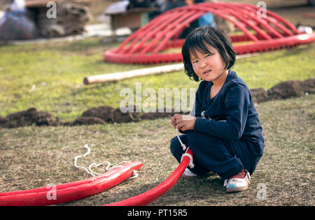 Kyrchyn Gorge, Kirghizistan, 6 Settembre 2018: bambina aiutare la sua famiglia ad abbattere un yurt Foto Stock