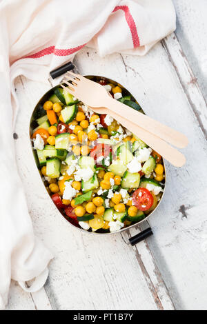 Scatola di pranzo di insalata con ceci arrosto con curcuma, feta, cetriolo, pomodori e prezzemolo Foto Stock