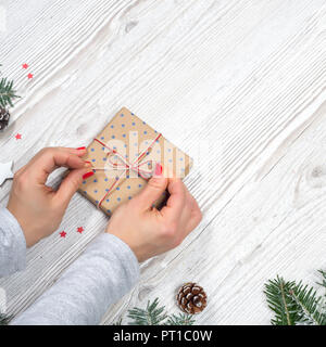Confezione regalo in mani con sfondo di Natale Foto Stock