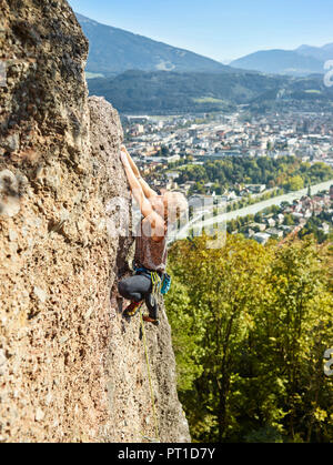 Austria, Innsbruck, Hoettingen cava, donna di arrampicata in parete di roccia Foto Stock