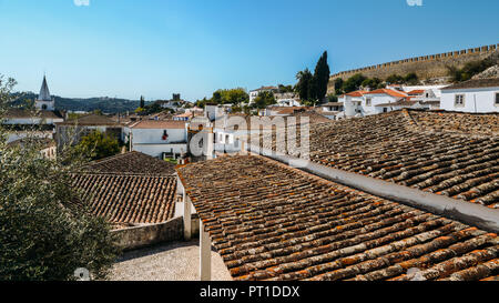 Alta perspecetive vista dei tetti in terracotta entro la città fortificata di Obidos, Oeste, Distretto di Leiria, Portogallo, Europa Foto Stock