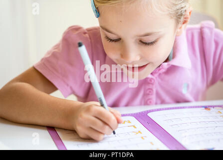 Sorridente bambina alfabeto di scrittura Foto Stock