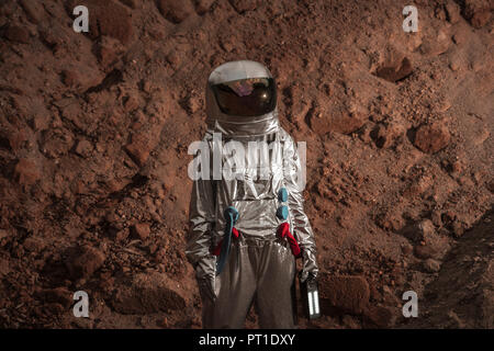 Spaceman esplorando il pianeta anonimi, tenendo in mano la torcia Foto Stock