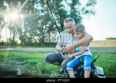 Nonno e nipote insieme di pesca sul lungolago Foto Stock