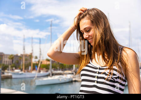 Sorridente giovane donna a marina Foto Stock