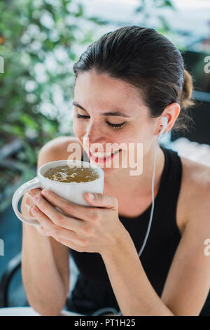 Giovane imprenditrice seduta nella caffetteria, prendendo una pausa, bere il tè Foto Stock