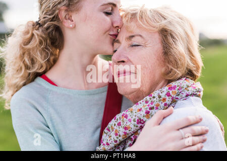 Nipote di baciare la nonna Foto Stock