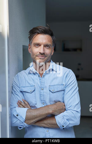 Ritratto di uomo sorridente indossando la luce blu denim shirt Foto Stock