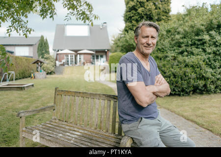 Ritratto di sorridere uomo maturo nel giardino della sua casa Foto Stock