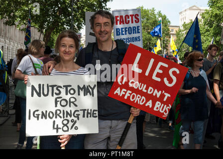 Sorridente coppia giovane su anti Brexit rally portando cartelli 'dadi a maggio per ignorare il 48%' e 'bugie non potevo permettermi un bus". Foto Stock