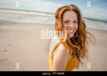 Ritratto di una donna redheaded, ridevano allegramente sulla spiaggia Foto Stock