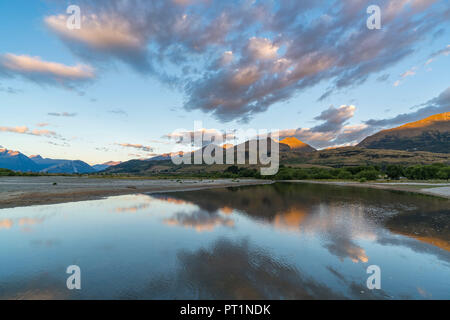 Nuvole nel cielo sopra sul lago Wakatipu e sulle montagne al tramonto, Glenorchy, Queenstown distretto dei laghi, regione di Otago, South Island, in Nuova Zelanda, Foto Stock