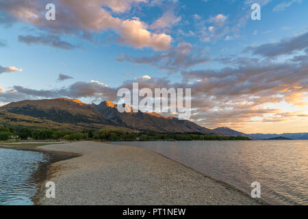 Nuvole nel cielo sopra sul lago Wakatipu e sulle montagne al tramonto, Glenorchy, Queenstown distretto dei laghi, regione di Otago, South Island, in Nuova Zelanda, Foto Stock