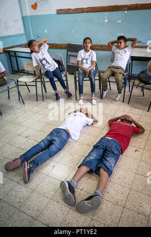 Betlemme, Palestina. Xiv Feb, 2018. Gli studenti sono visti in un dramma classe ri-agiscono in una situazione in cui i giovani palestinesi sono stati arrestati dalle forze israeliane durante il summer camp.Il ritorno Summer Camp è stato organizzato per i bambini del campo profughi di Aida, è stato istituito nel 1950 dai palestinesi che erano stati espulsi dalle loro case da 27 città in tutta la Palestina, cioè Nasra, Tabaria, Gerusalemme, acro, Jaffa, Haifa e Hebron. Questa è una quarta generazione di profughi, 130 bambini che vanno da 4 a 16 anni di età era dominato da 20 istruttori e volontari ed è stato finanziato da Foto Stock