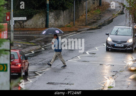 Chippenham, Regno Unito, 6 ottobre 2018. Un uomo a piedi è raffigurato sfidando la pioggia in Chippenham come heavy rain docce fanno la loro strada attraverso il sud dell'Inghilterra. Credito: Lynchpics/Alamy Live News Foto Stock