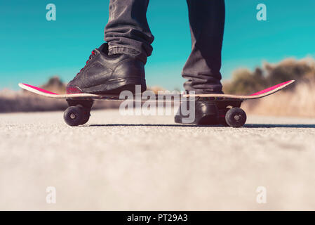 Pattinatore in piedi su skateboard Foto Stock