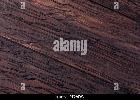 Legno pregiato texture. Di aspetto rustico e scuro, ocra, marrone, tostato, toni di nero. Le venature e i nodi sono apprezzati. Foto Stock