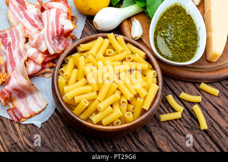 Ingredienti per fare in casa il pesto maccheroni. Con cipolla e pancetta, formaggio, basilico, pinoli, aglio. Foto Stock