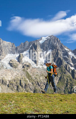 Un trekker è a piedi nella parte anteriore delle Grandes Jorasses durante il Mont Blanc escursioni (Val Ferret, Courmayeur, provincia di Aosta, Valle d'Aosta, Italia, Europa) Foto Stock