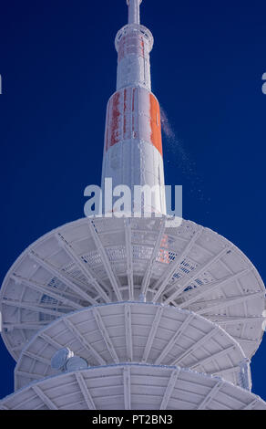 Con la neve e il ghiaccio coperto torre di trasmissione sul Brocken nella parte anteriore di un cielo blu scuro Foto Stock