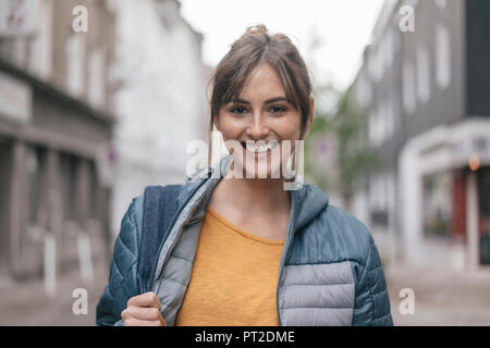 Ridendo donna passeggiate in città Foto Stock
