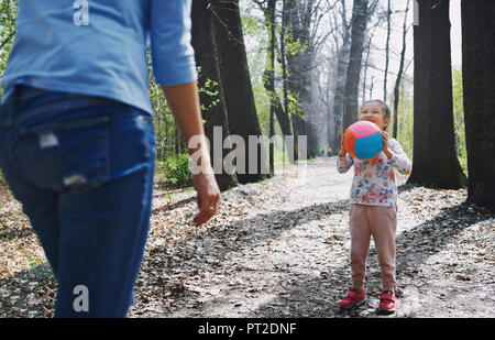 Madre e figlia giocare a palla in un parco Foto Stock