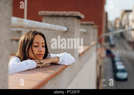 Ritratto di giovane donna in relax sulla terrazza del tetto Foto Stock