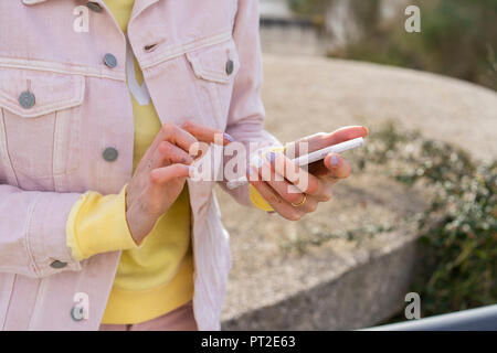 Giovane donna utilizza lo smartphone Foto Stock