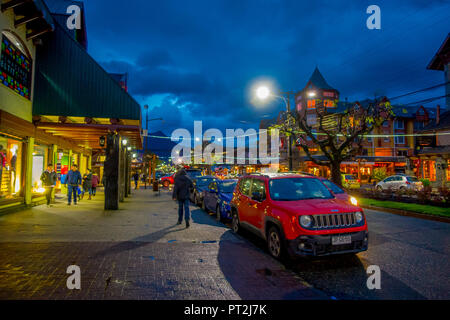 PUCON, Cile - SETTEMBRE, 23, 2018: veduta esterna di automobili parcheggiate in una fila per le strade della città in Pucon di notte Foto Stock