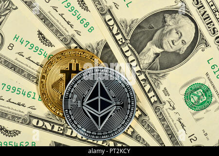 Immagine simbolica di valuta digitale, argento fisico coin Ethereum e golden moneta fisica Bitcoin sulla banconota dollaro USA Foto Stock